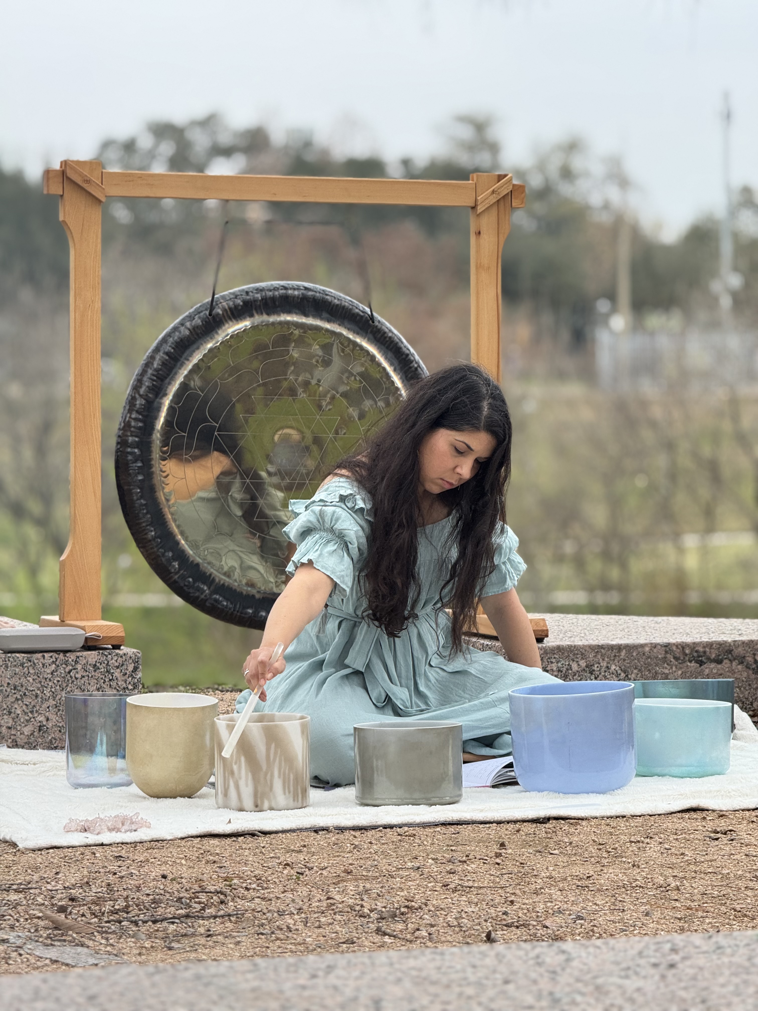 Laura Maesaka playing singing bowls by the bayou