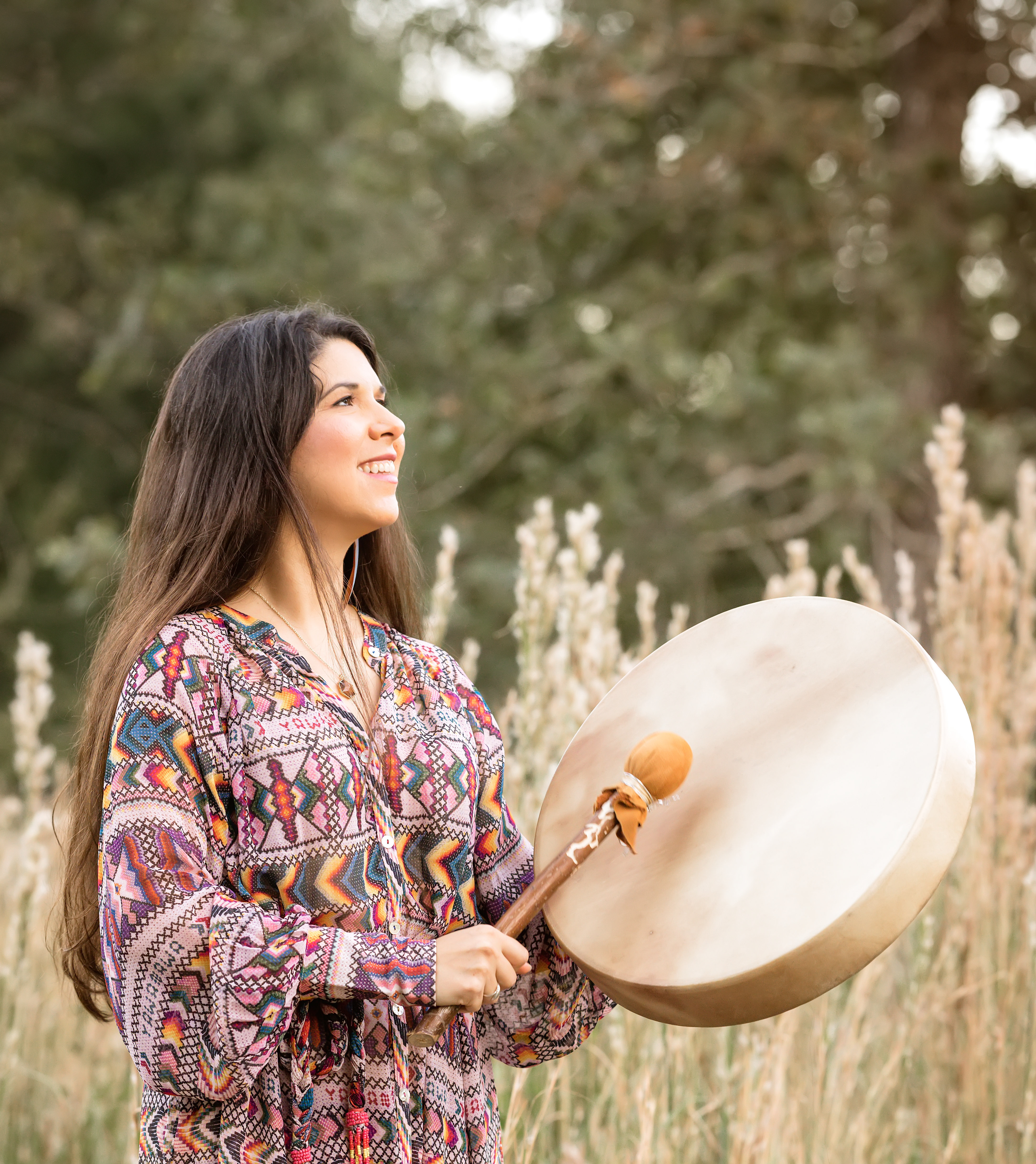 Laura Maesaka smiling while playing a drum outdoors